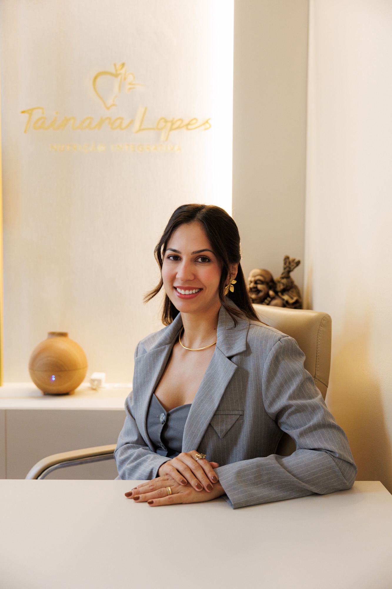 Tainara Lopes, nutricionista, sentada no consultório